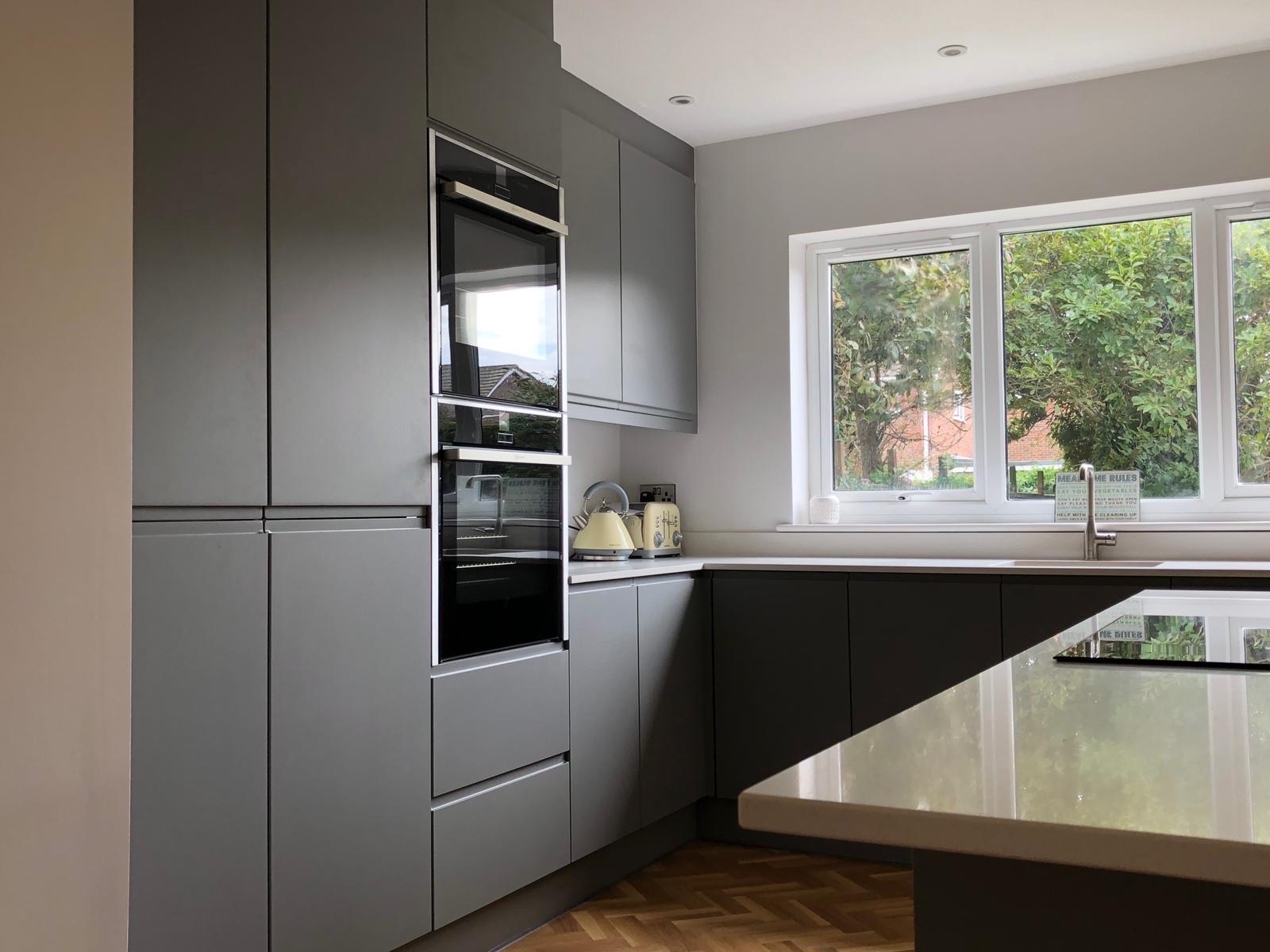 Kitchen grey matte tall units window, made and fitted by Sussex Design Interiors